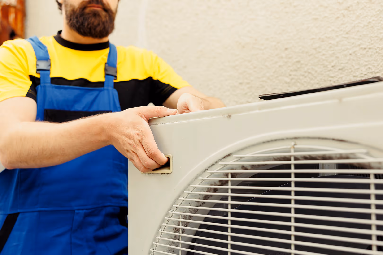 A man holding up an air conditioning unit