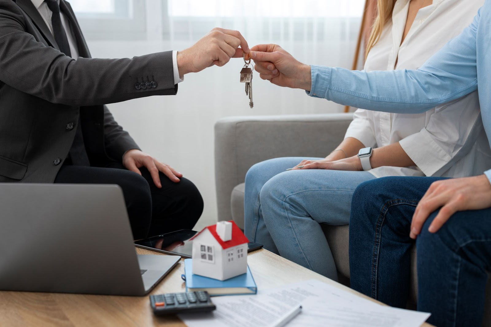 Agente inmobiliario entregando llaves de casa a nueva propietaria