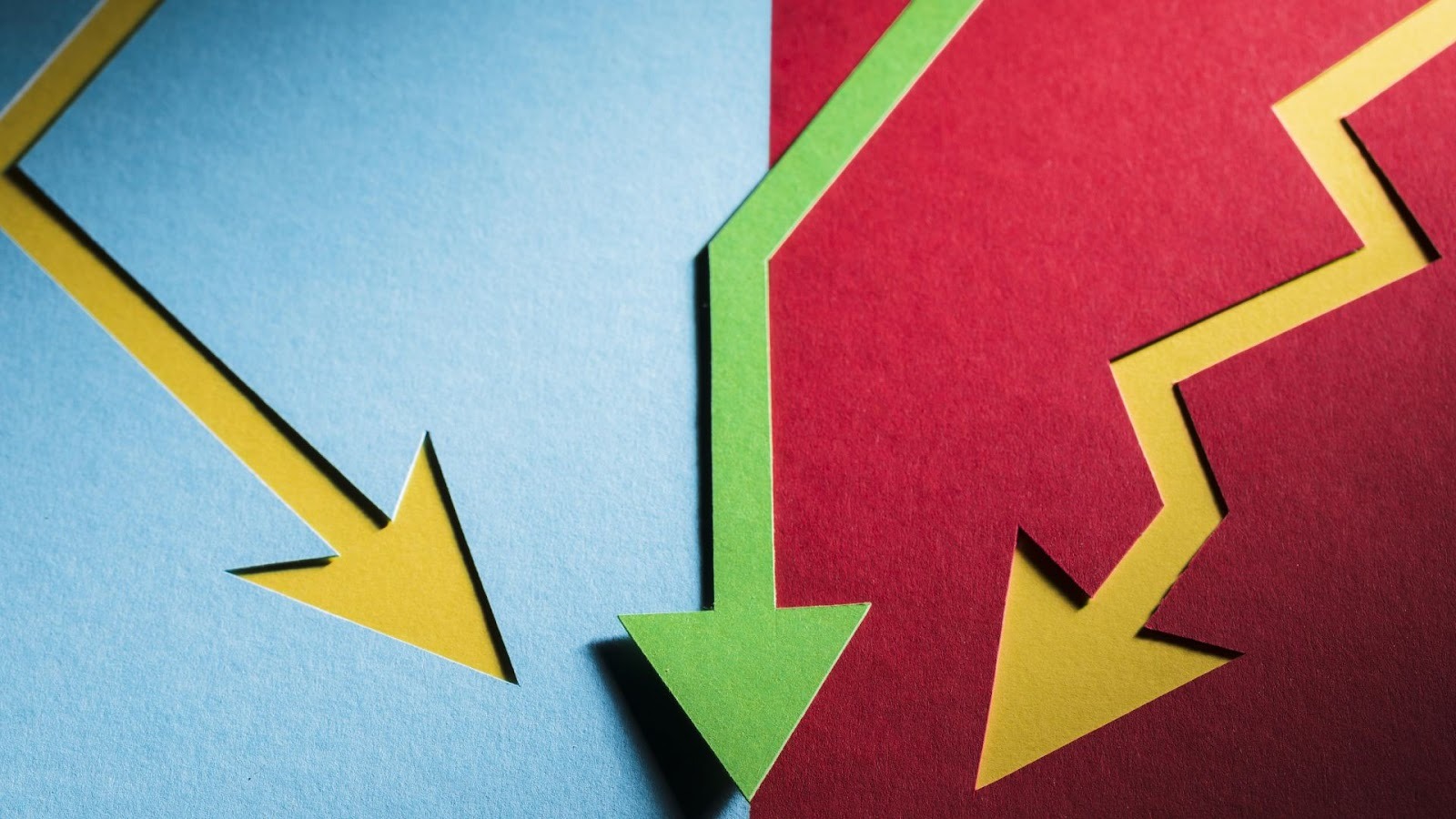 Flechas de colores en direcciones descendentes sobre fondo bicolor representando decline financiero