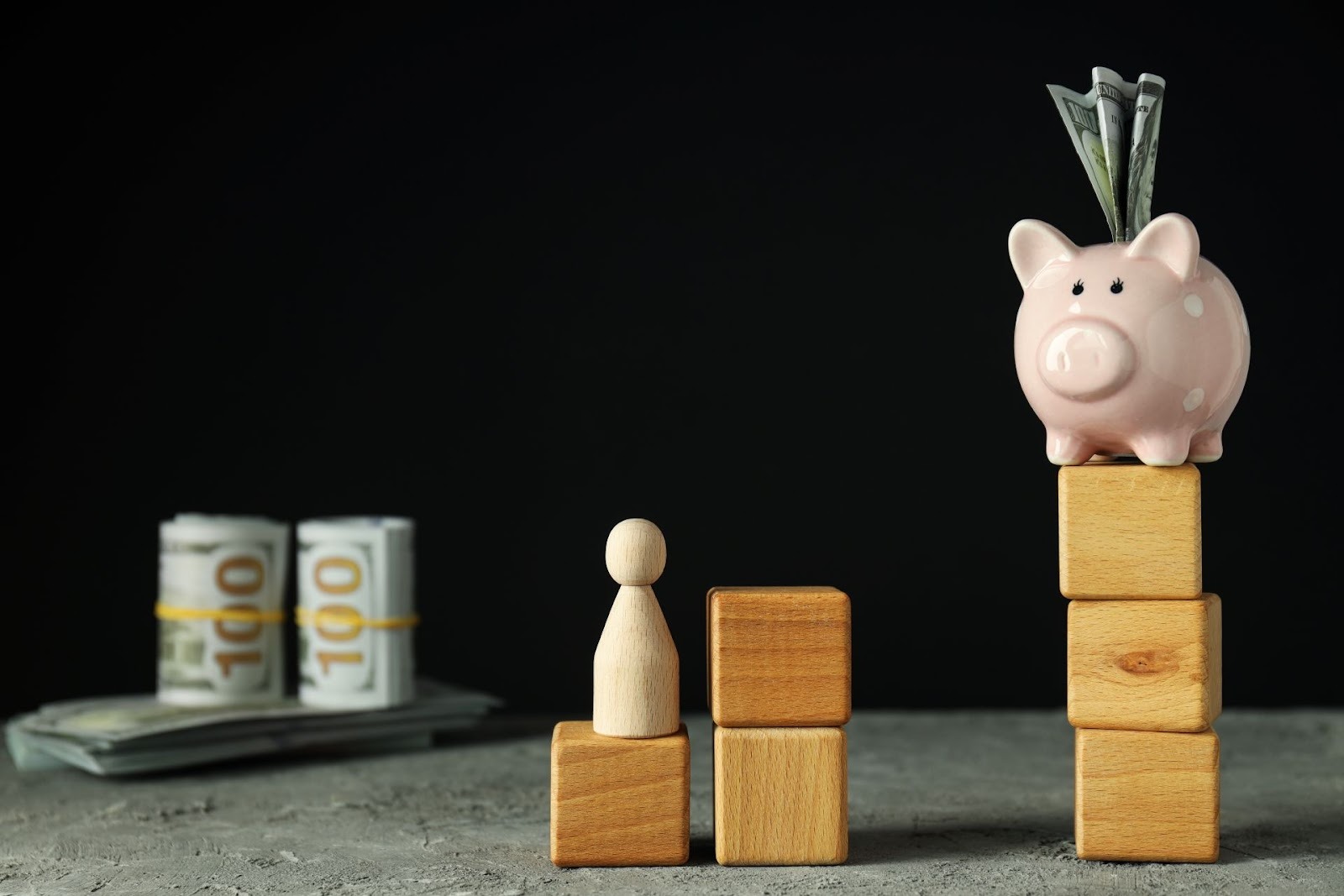 Alcancía rosa con dólares sobre bloques de madera representando crecimiento financiero y ahorro