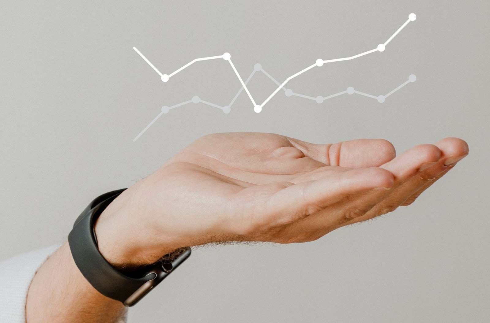 Mano extendida mostrando gráficos de líneas digitales simbolizando crecimiento de inversiones