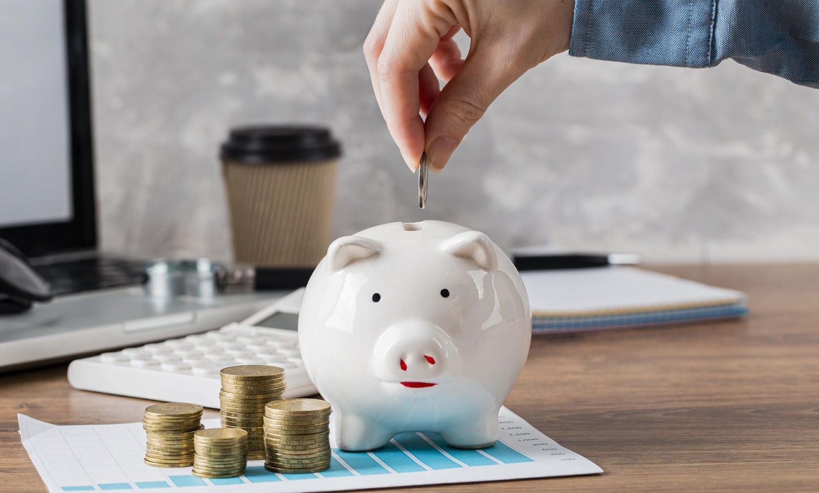 Alcancía blanca con monedas apiladas significado págate primero prioridad ahorro