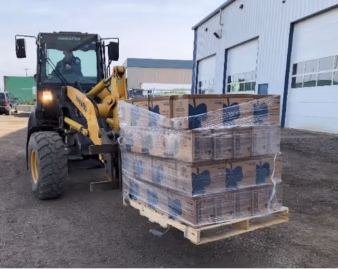 A tractor carrying boxes on a pallet