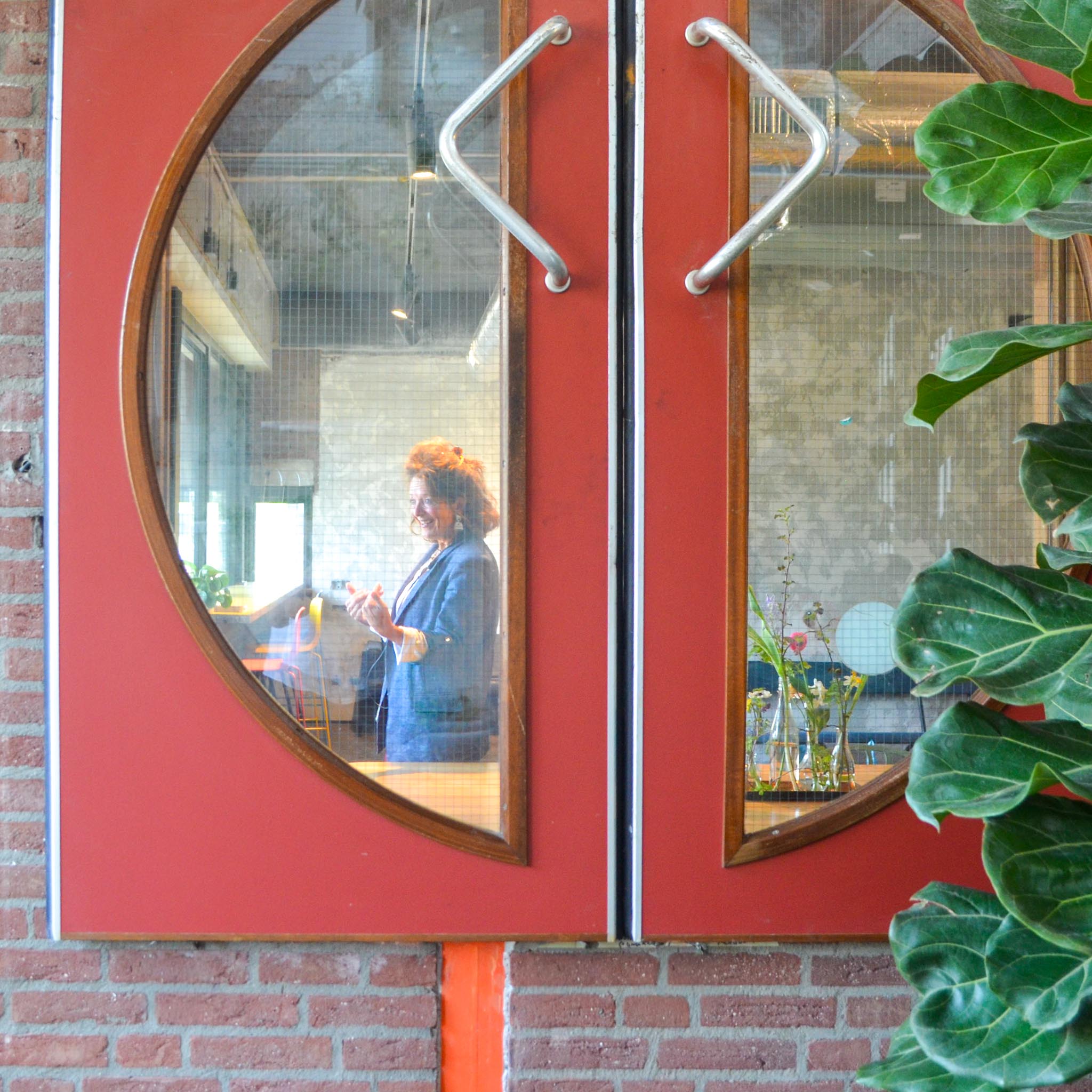 Man wijst naar een diagram over symptomen en structuur tijdens een presentatie aan een groep mensen.