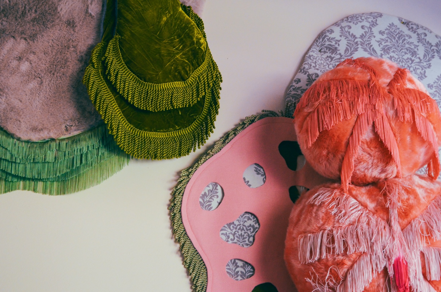 Detail een abstract driedimensionaal kunstwerk van zachte textiel met meerdere kleuren, patronen en structuren.