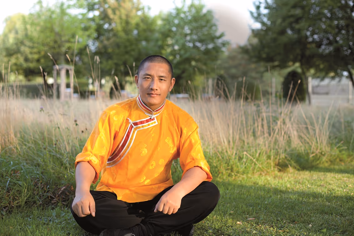 Tulku Lobsang Rinpoche zittend op een grasveld in een natuurlijke omgeving