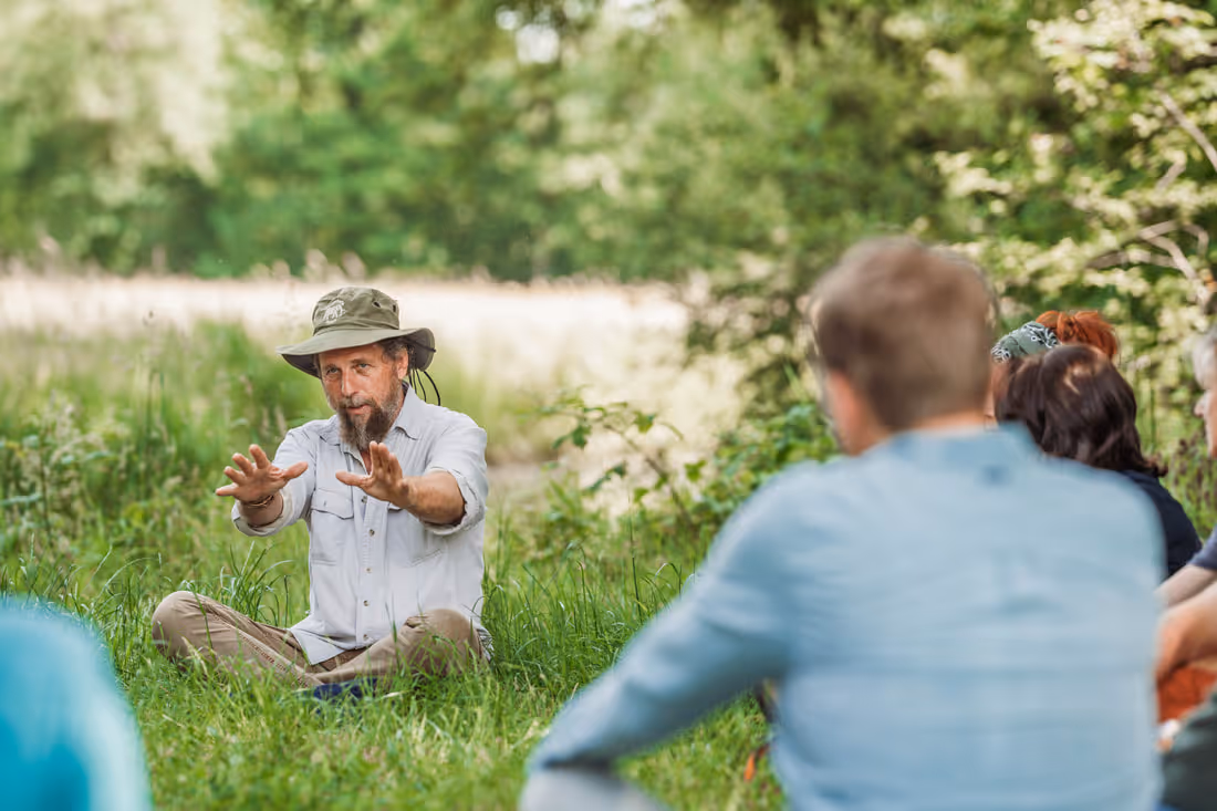 Gids Alan McSmith zit in de wildernis deelnemers van een tocht te vertellen over wat hij ziet in de natuur