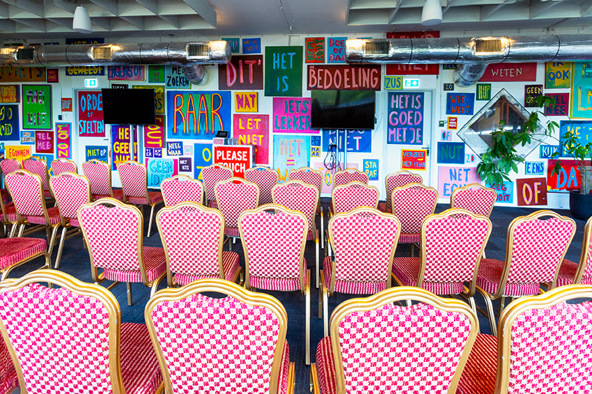 Rode stoelen in theateropstelling in de kleurrijke vergaderruimte Circus Andersom bij De Groene Afslag.