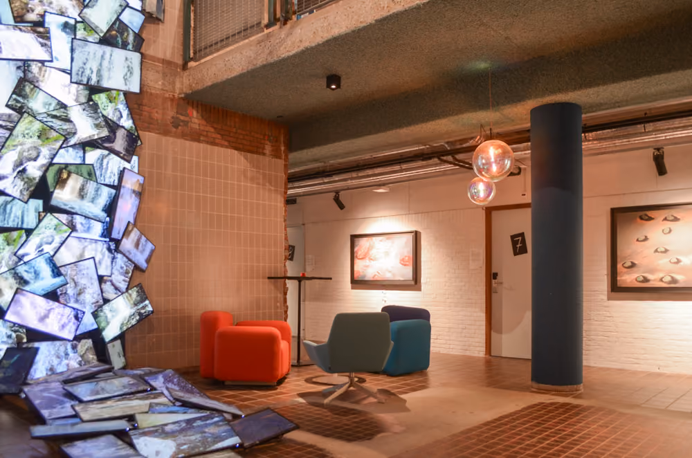 Hotellobby met in de linker hoek van de foto een groot kunstwerk gemaakt van beeldschermen