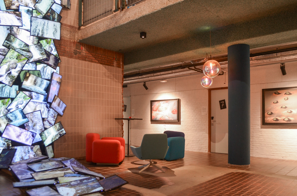 Hotellobby met in de linker hoek van de foto een groot kunstwerk gemaakt van beeldschermen