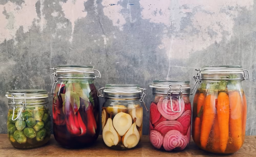 Foto van vijf potter met verschillende gefermenteerde groentes erin.