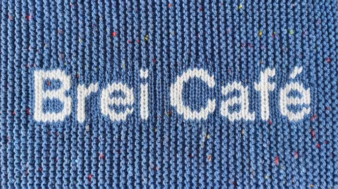Blauw breiwerkje met daarop de tekst brei café.