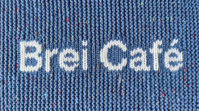 Blauw breiwerkje met daarop de tekst brei café.
