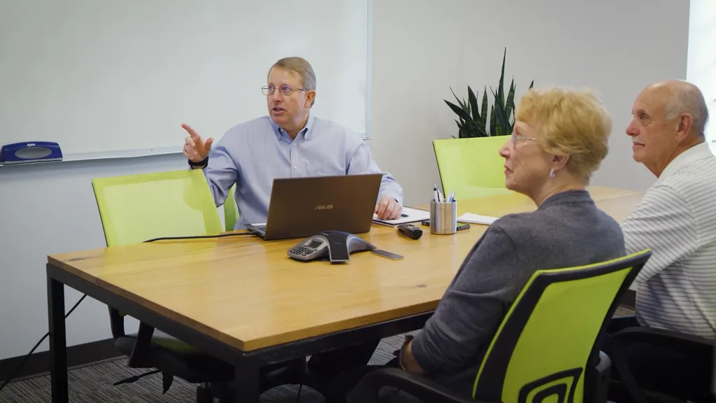 Financial advisor discussing retirement strategies with senior clients in a modern office setting, highlighting Colorado Wealth Group’s expert retirement and legacy planning services in Denver, CO