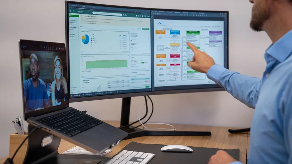 Financial advisor pointing at investment dashboard and planning flowchart during a virtual meeting with clients, demonstrating Colorado Wealth Group’s data-driven and remote wealth management solutions