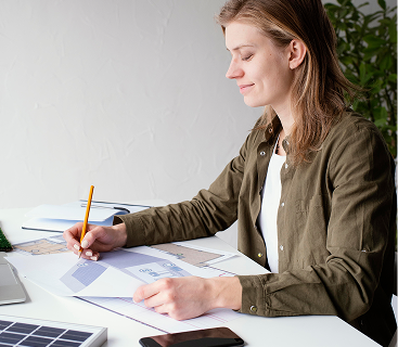 Woman reviewing financial documents and investment charts at a desk, illustrating personalized client-focused wealth planning services at Colorado Wealth Group