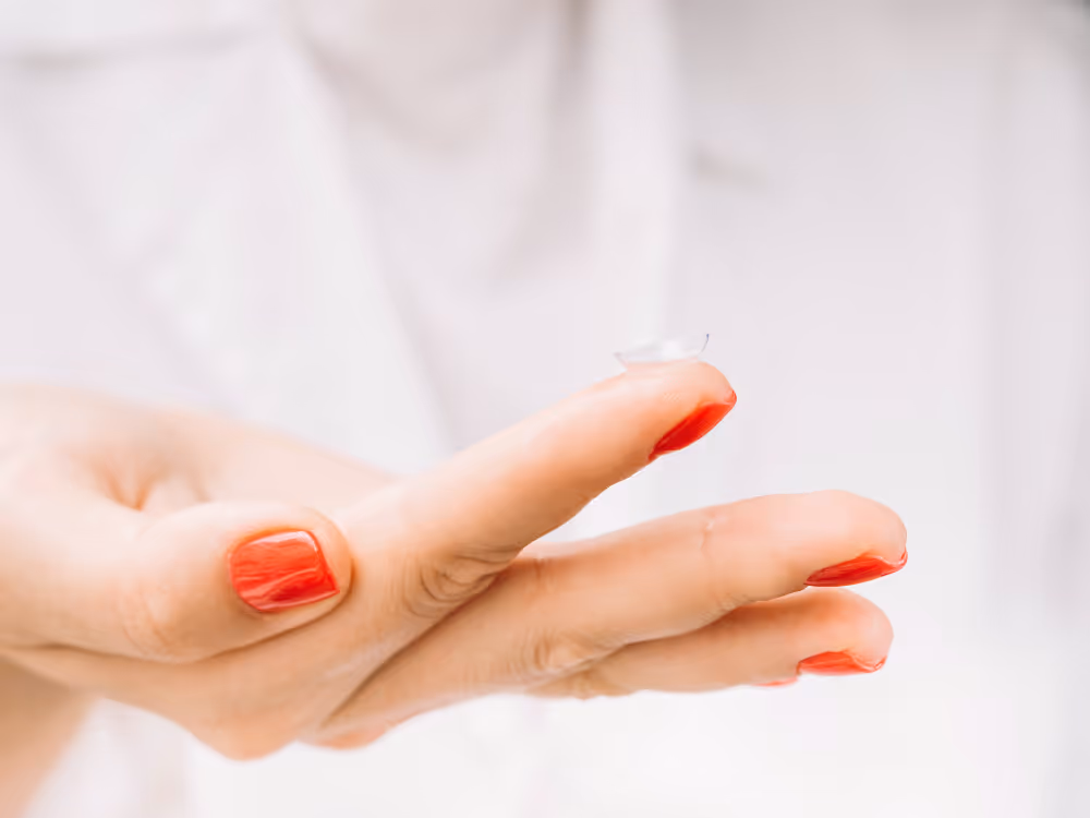Hand with bright red nail polish against soft white background