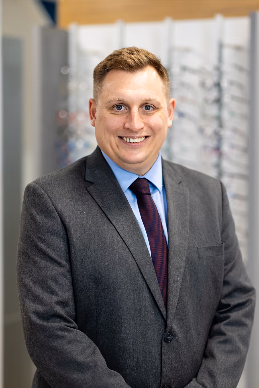 Smiling professional in gray suit and purple tie in office setting