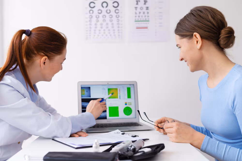 Eye doctor discussing test results with patient on laptop screen
