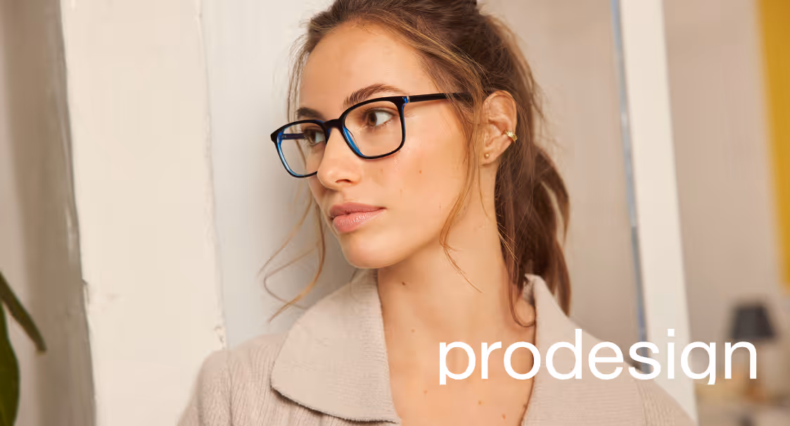 Woman with glasses in neutral-toned sweater looking thoughtfully to the side