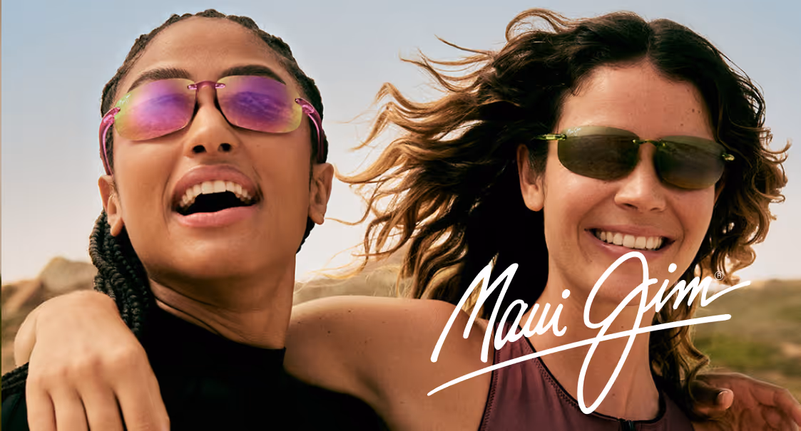 Two friends laughing, wearing colorful sunglasses in sunny outdoor setting