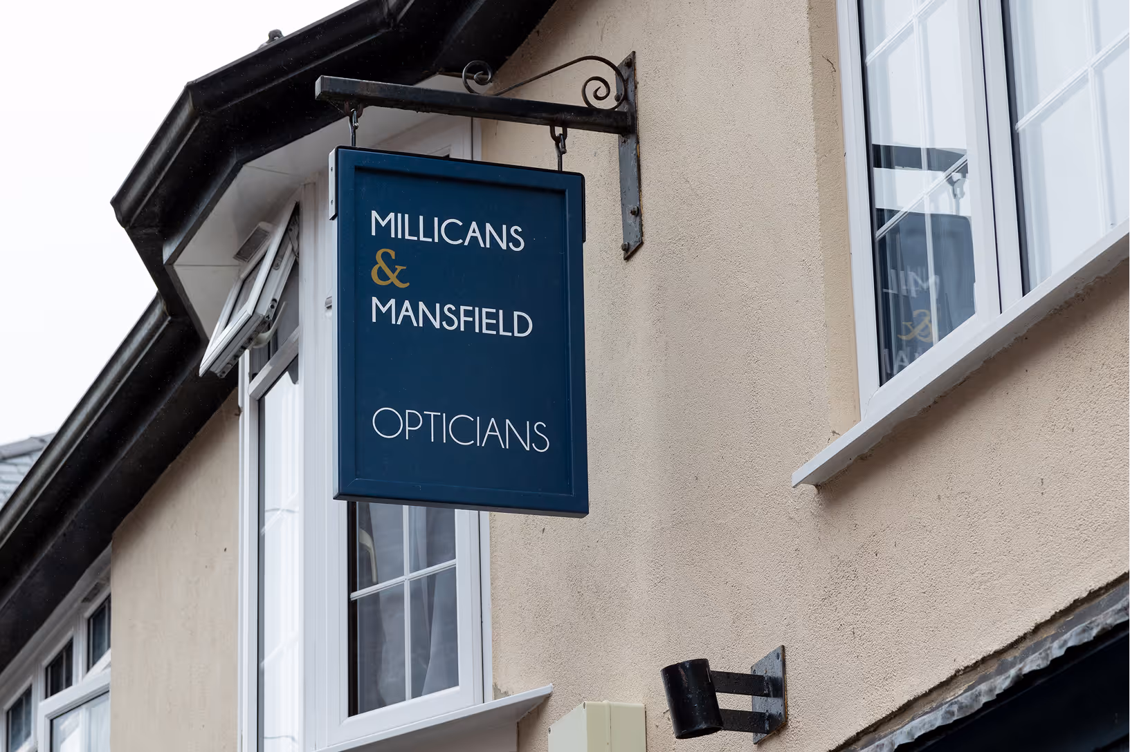 Millicans & Mansfield Opticians sign hanging on building exterior