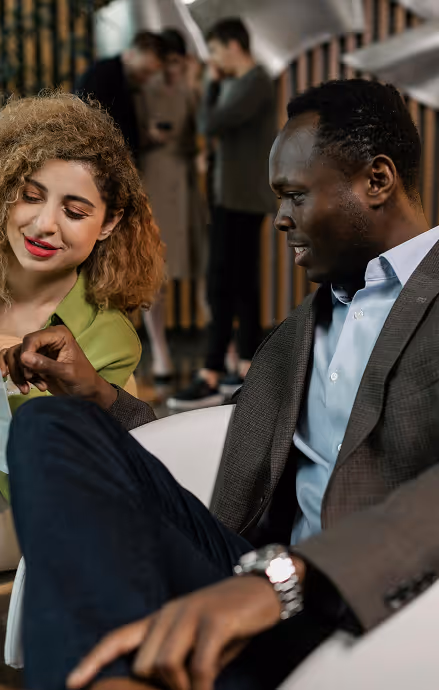 Stylish man and woman sitting in the reception of a cool office having a meeting
