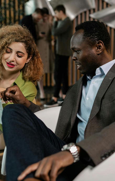 Stylish man and woman sitting in the reception of a cool office having a meeting