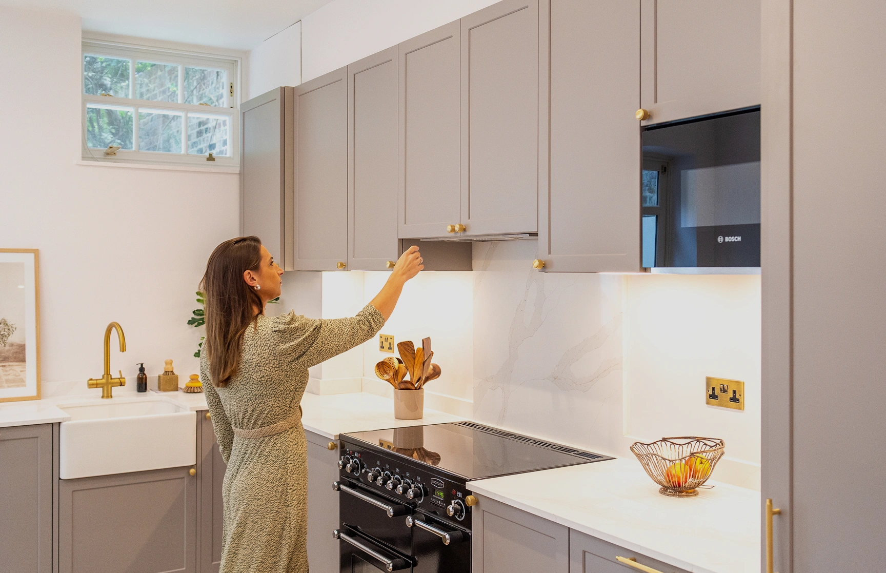 A lady reaching for a cupboard in a modern kitchen