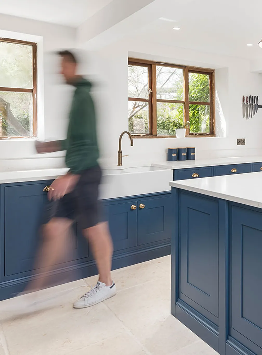 A client walking through and admiring the finished craftsmanship of their new bespoke shaker kitchen.