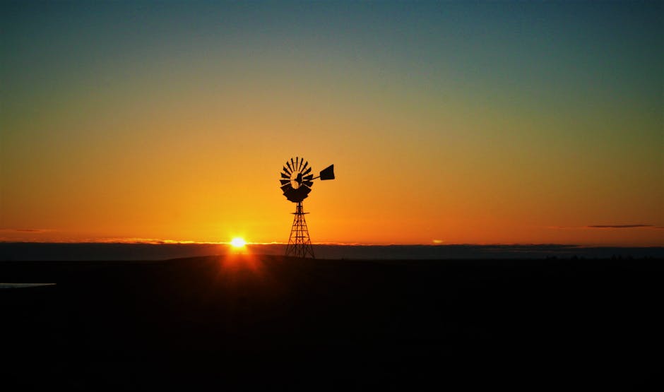 A scenic sunset view featuring a windmill silhouette against a vibrant Australian sky.