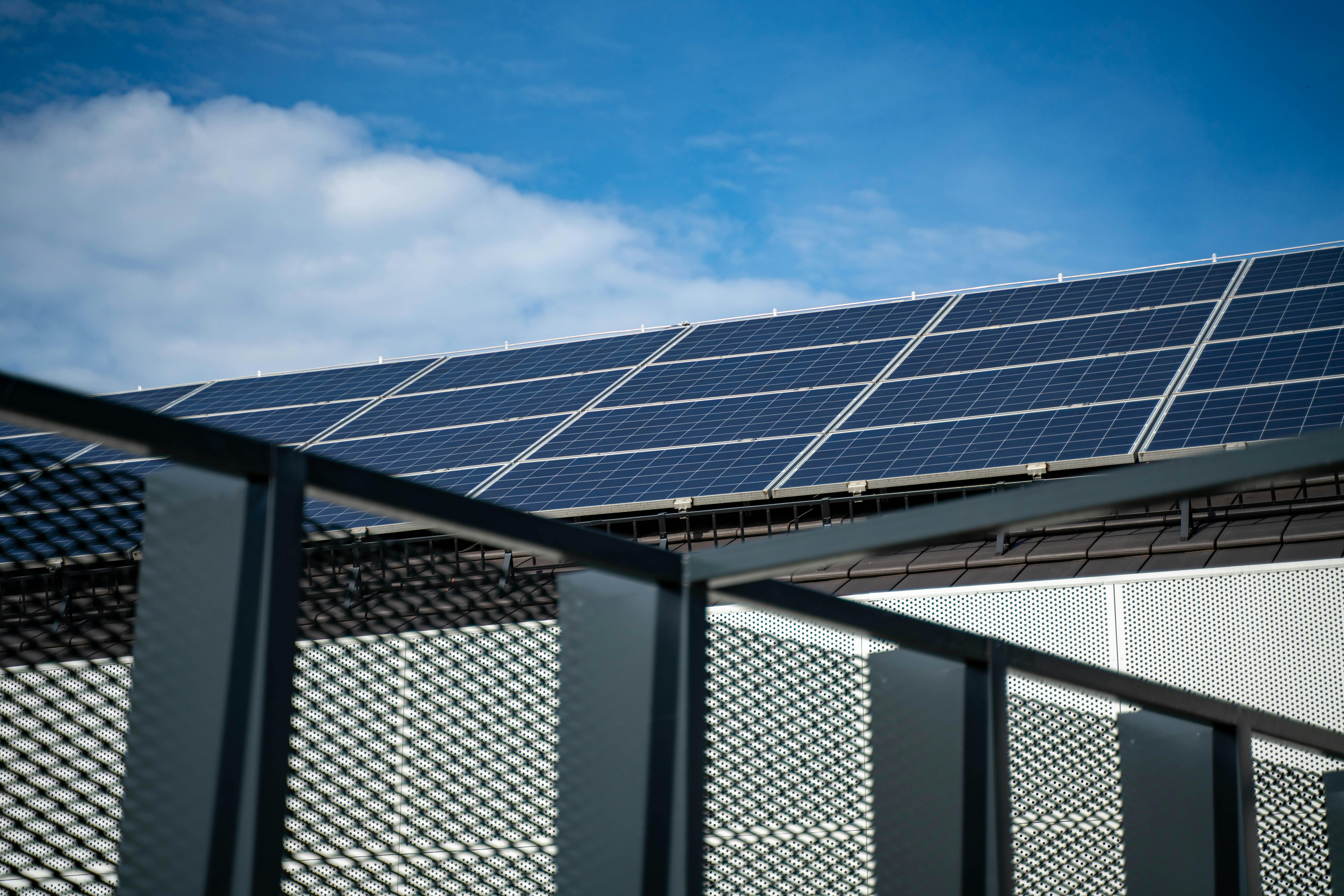 Modern solar panels arrayed on a residential rooftop under clear blue sky, showing how layout and design shape self-consumption value at home.