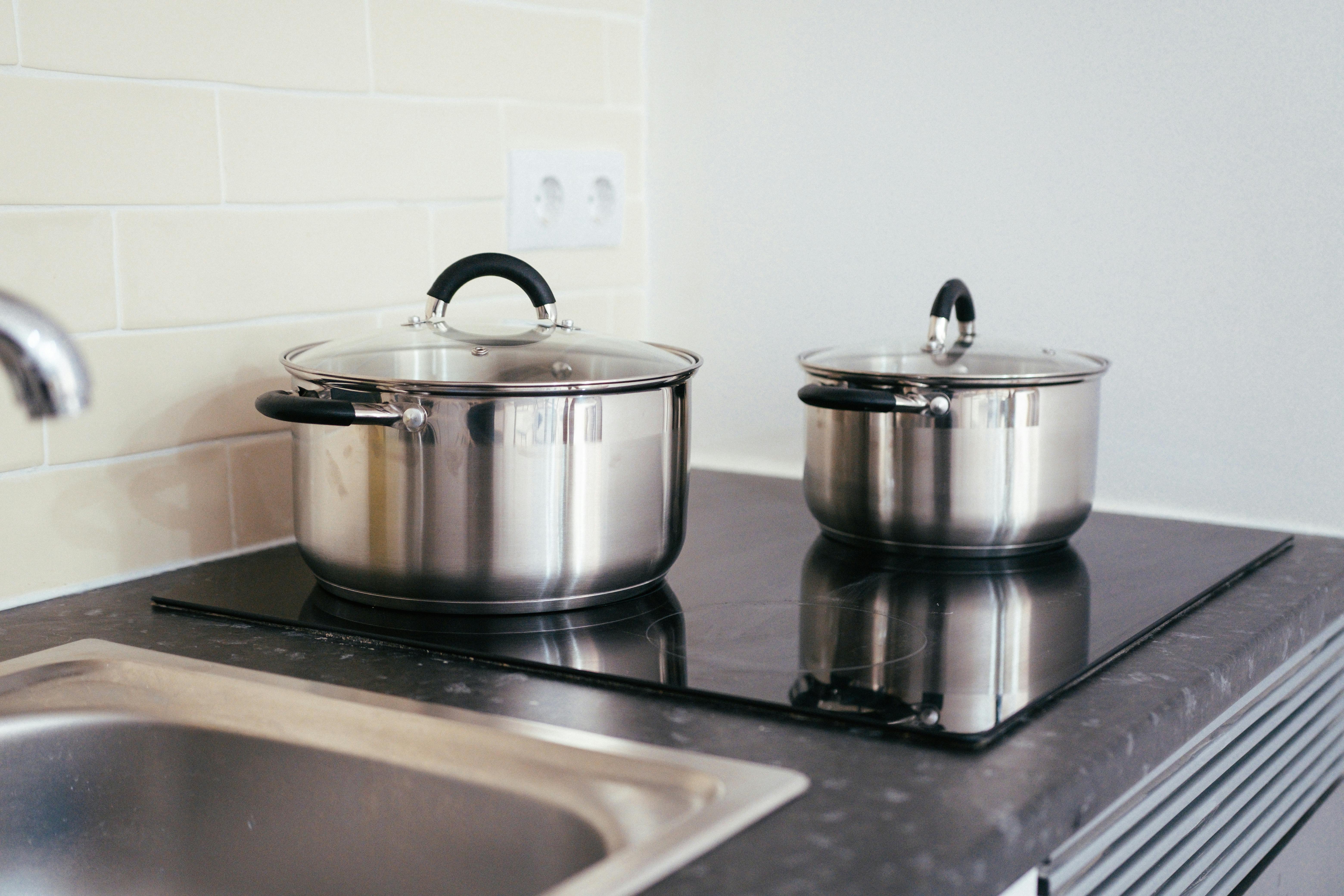 Contemporary kitchen with pots on an induction cooktop, an everyday example of home electrification replacing gas with electric appliances.