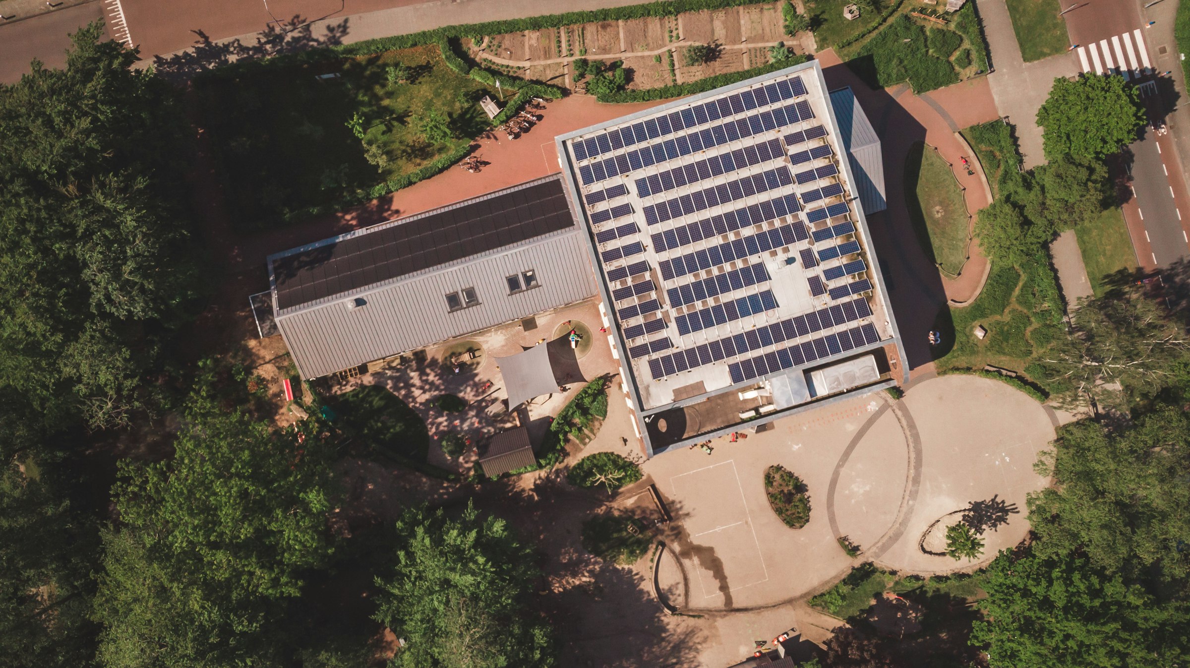 Aerial view of a commercial building rooftop covered in solar panels, the business scale system whose returns hinge on the tariff structure underneath.