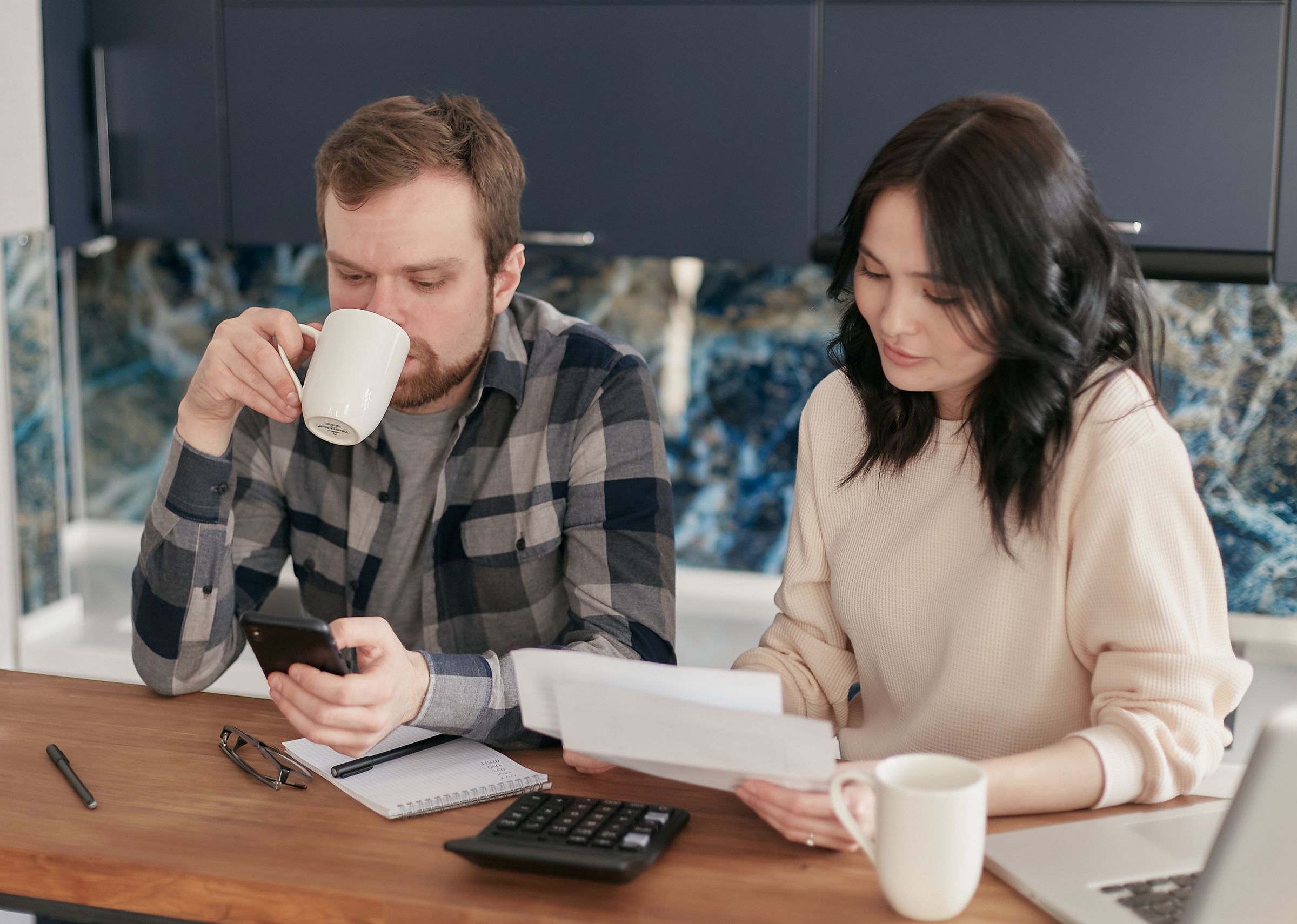 Australian household reviewing electricity bills at the kitchen table, the setting where falling feed-in tariffs and self-consumption trade-offs become real.