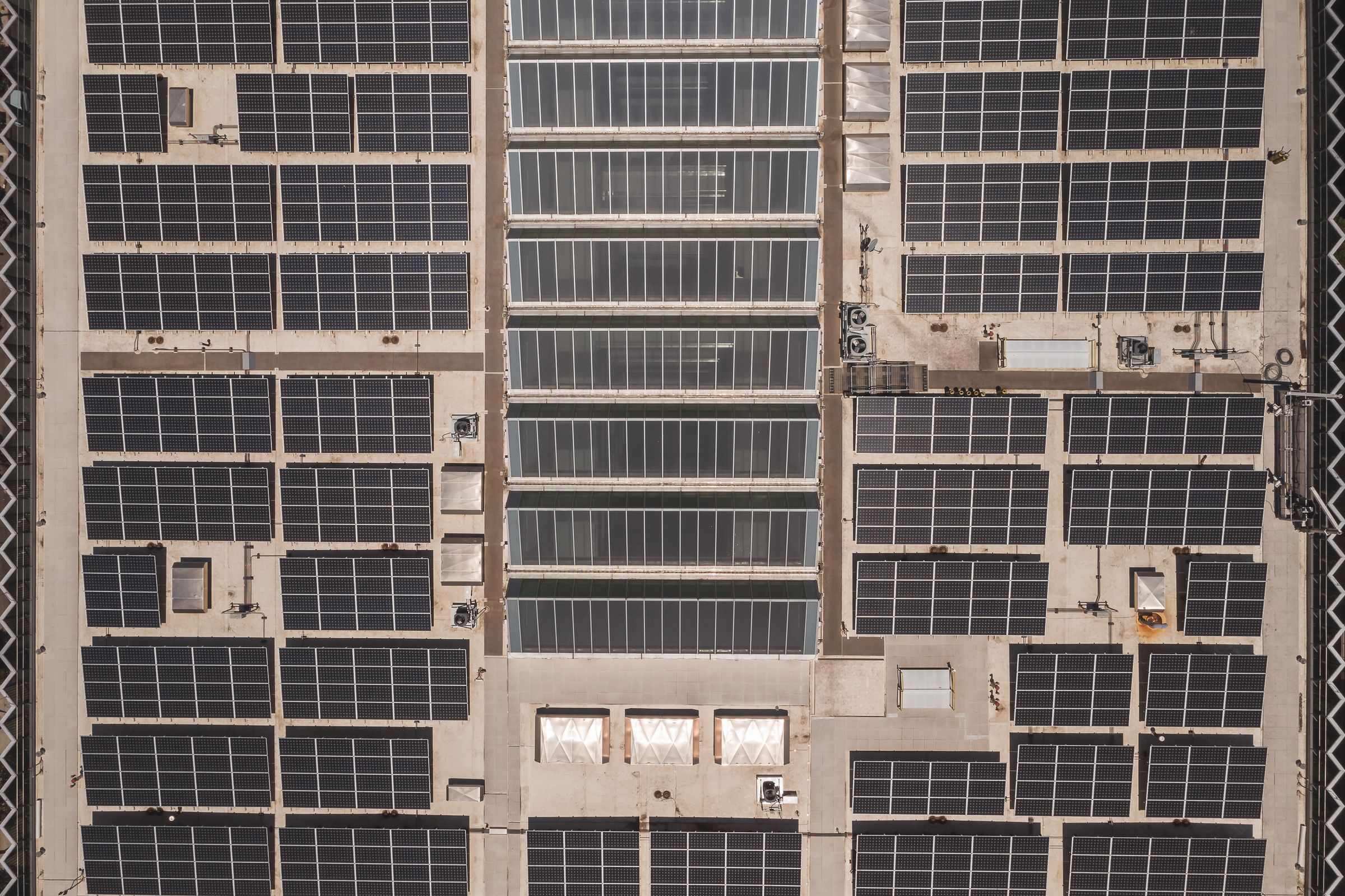Aerial view of solar panels covering an industrial rooftop, the type of commercial site where the installation process shapes long-term energy value.