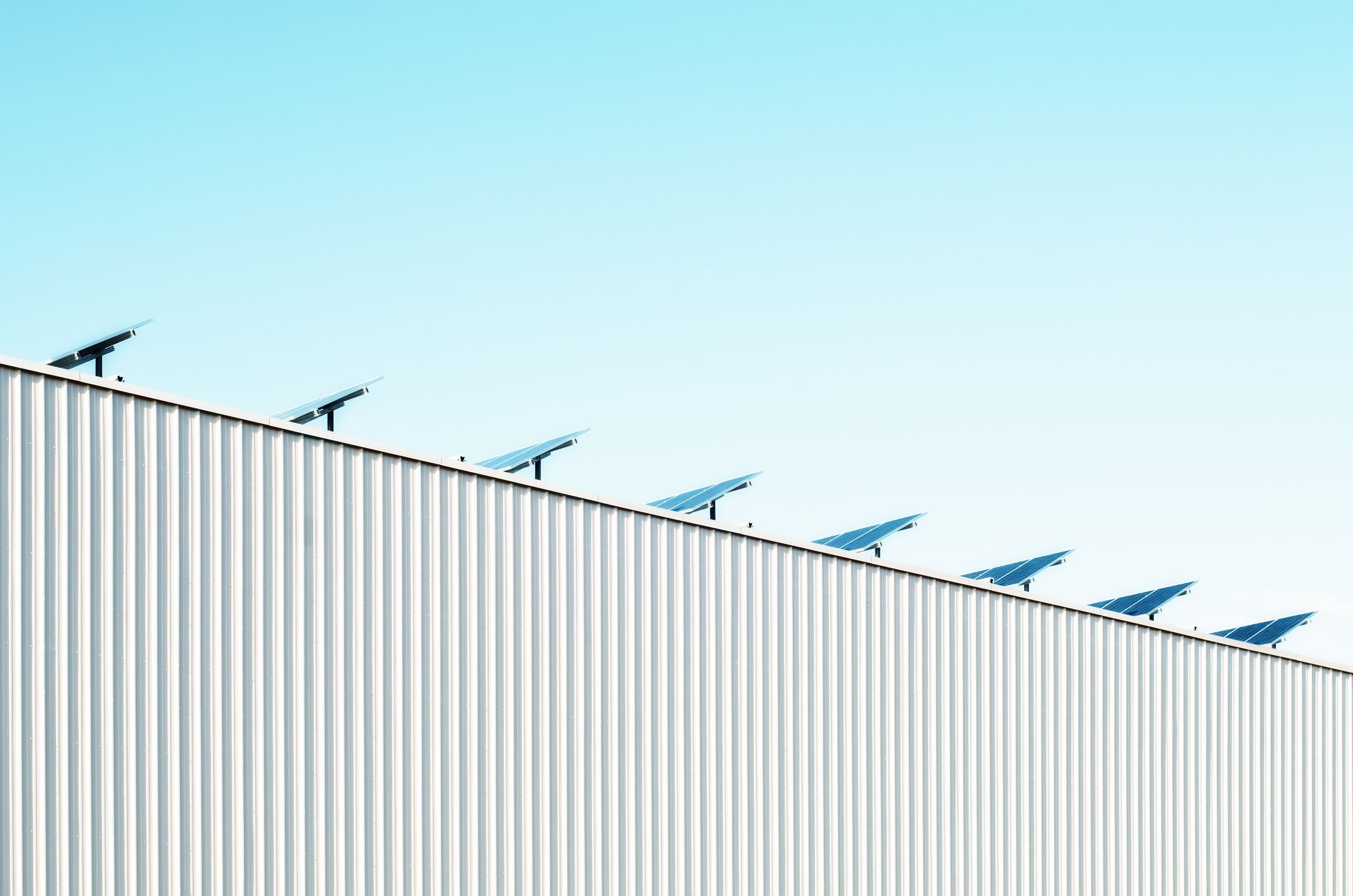 Commercial rooftop solar array on a corrugated steel building, showing how corporate sustainability strategies take shape at an actual Australian site.