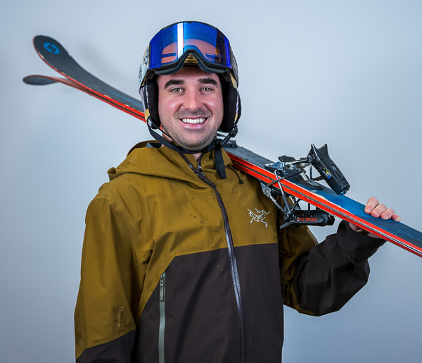Matthew Conley, Operations Coordinator at Colorado Wealth Group, smiling while holding skis over his shoulder, dressed in a ski jacket and helmet, showcasing his love for outdoor adventure.