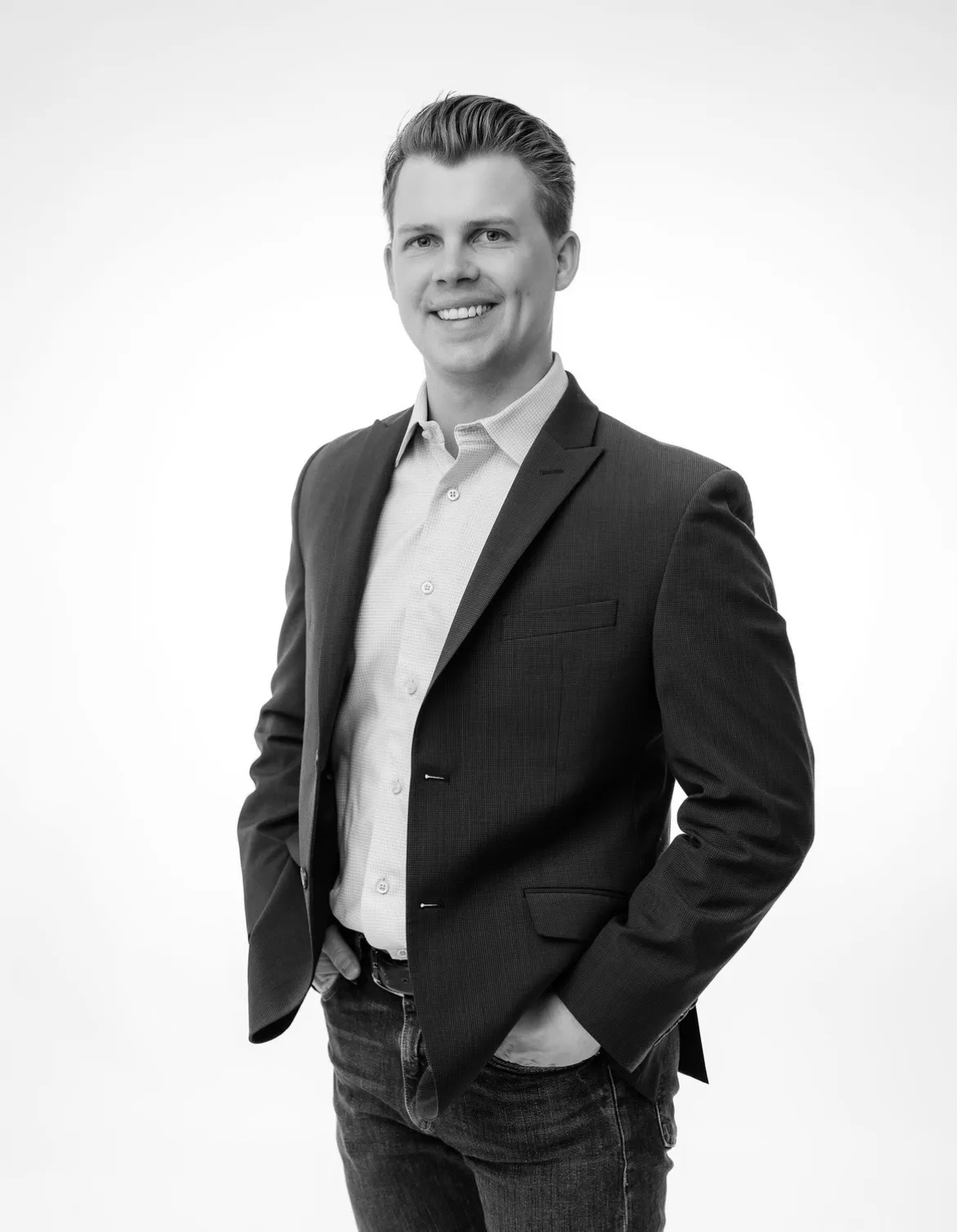 Ian Snedden, Head of Tax & Accounting at Colorado Wealth Group, standing confidently with hands in pockets, dressed in a blazer and shirt, photographed against a plain white background.