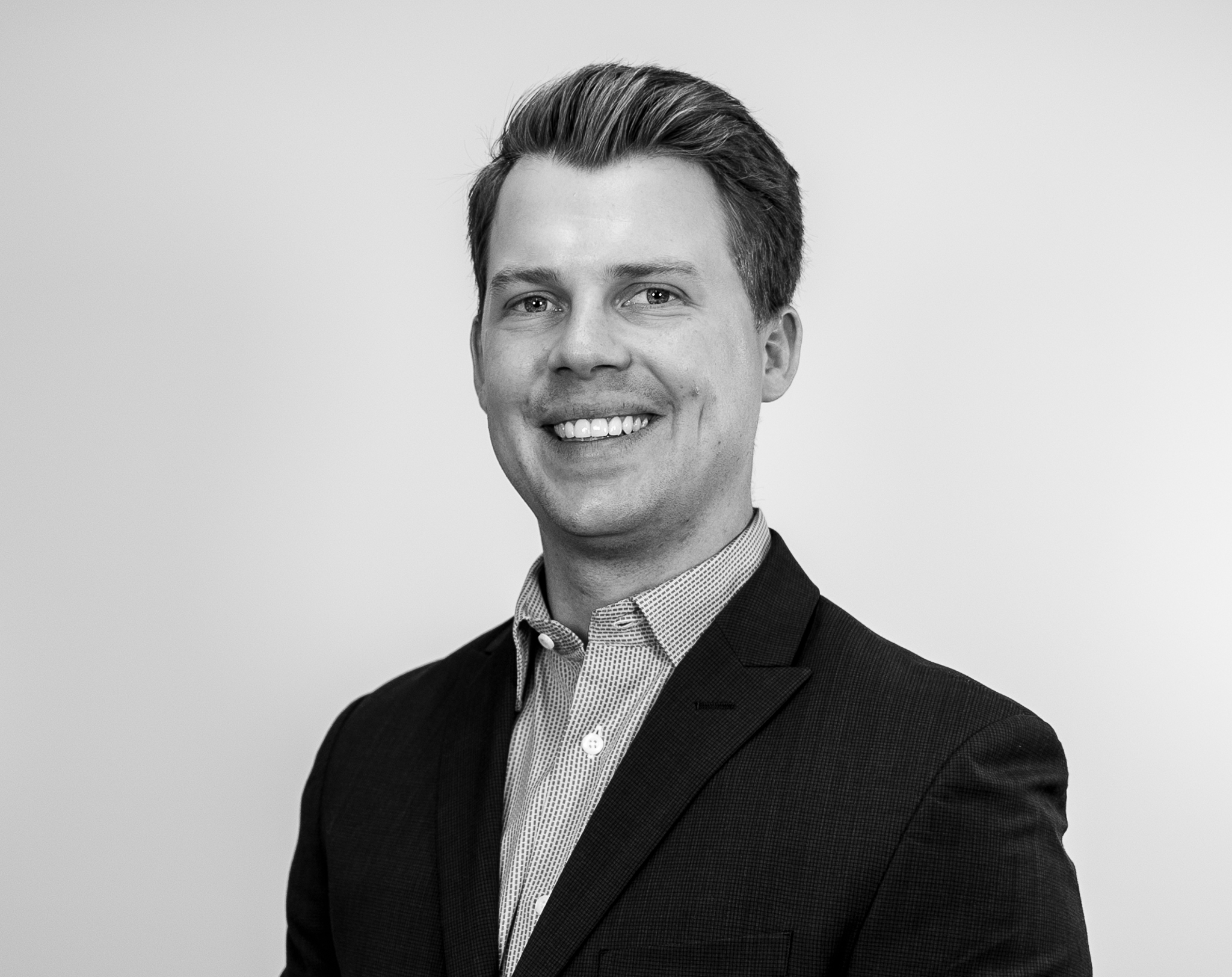 Ian Snedden, Head of Tax & Accounting at Colorado Wealth Group, standing confidently with hands in pockets, dressed in a blazer and shirt, photographed against a plain white background.