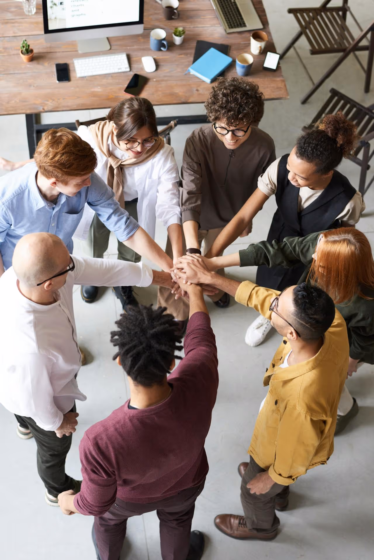 Group of neuroleadership staff with their hands together in a circle
