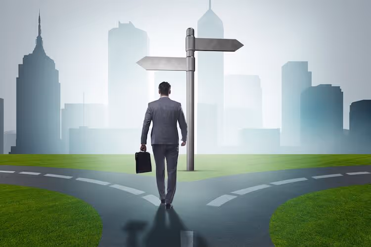 A man walking on a road which splits into 2 opposing directions