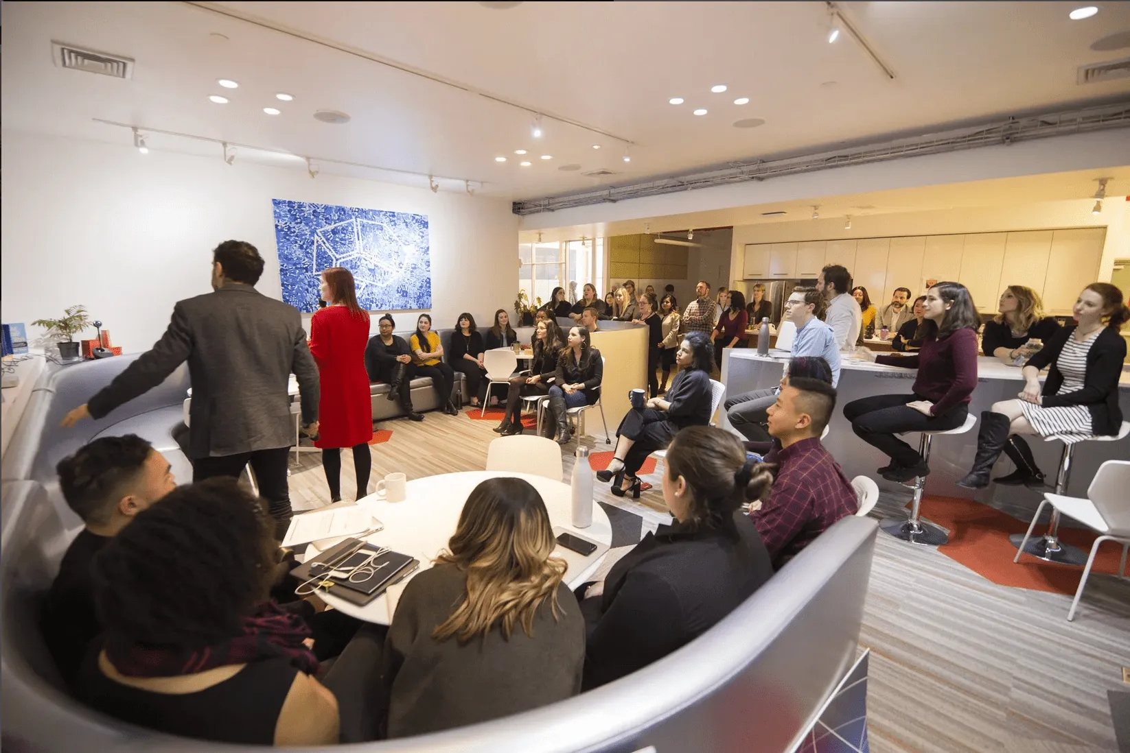 People sat round a curved desk in an office