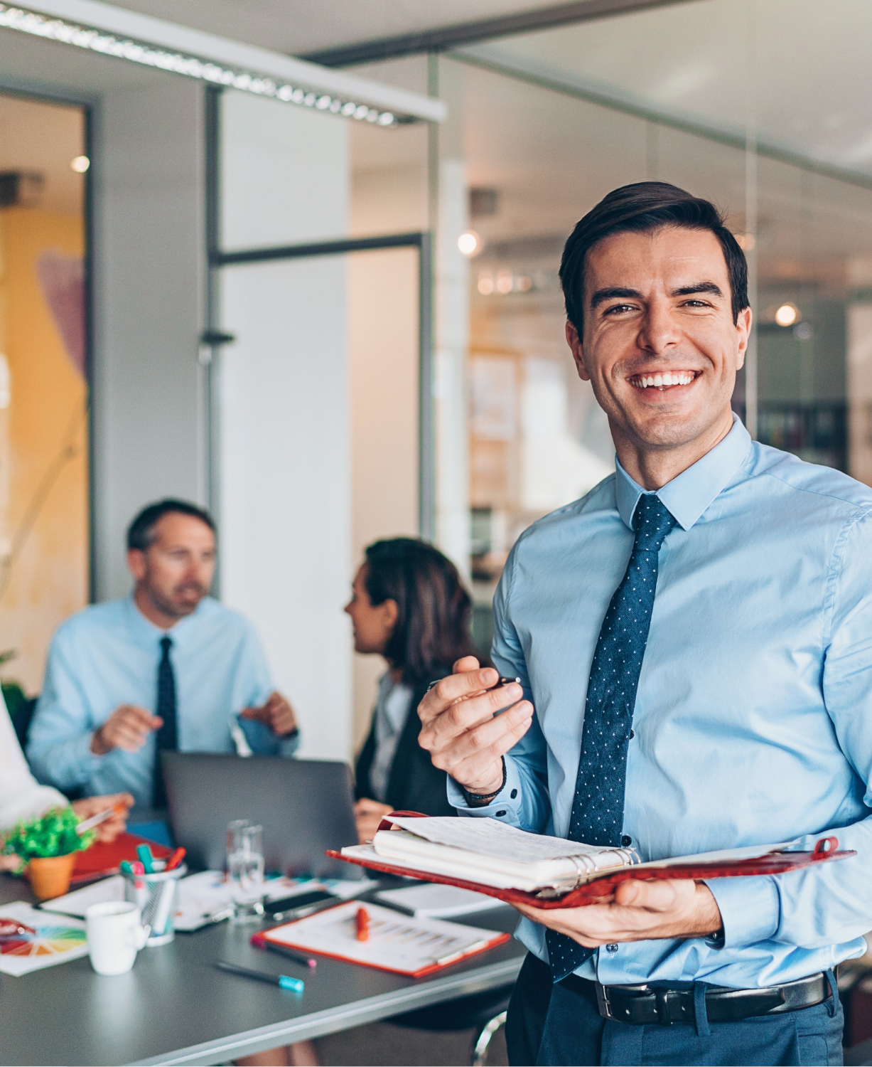 Three people sitting and standing while smiling