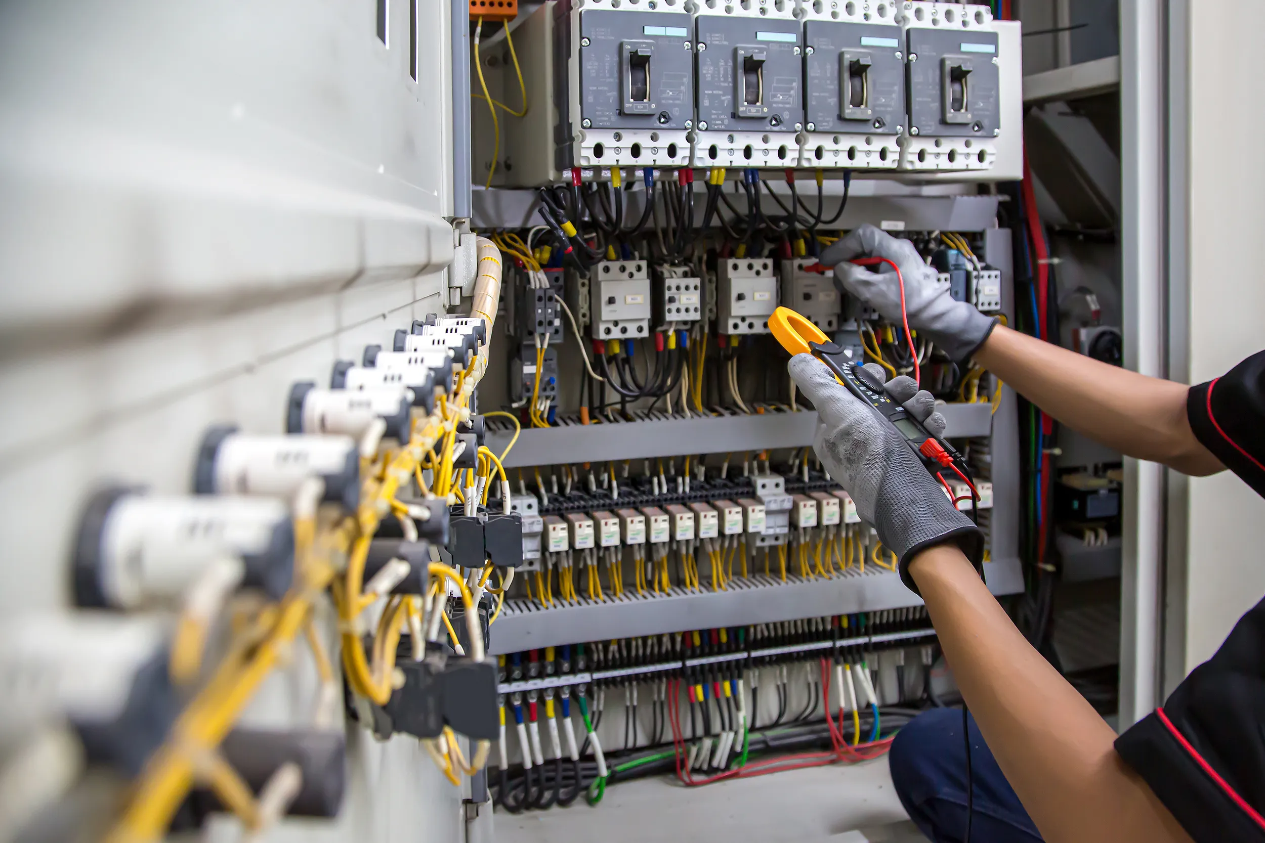 Technicus voert meting uit in een elektrische kast tijdens onderhoud en technische controle