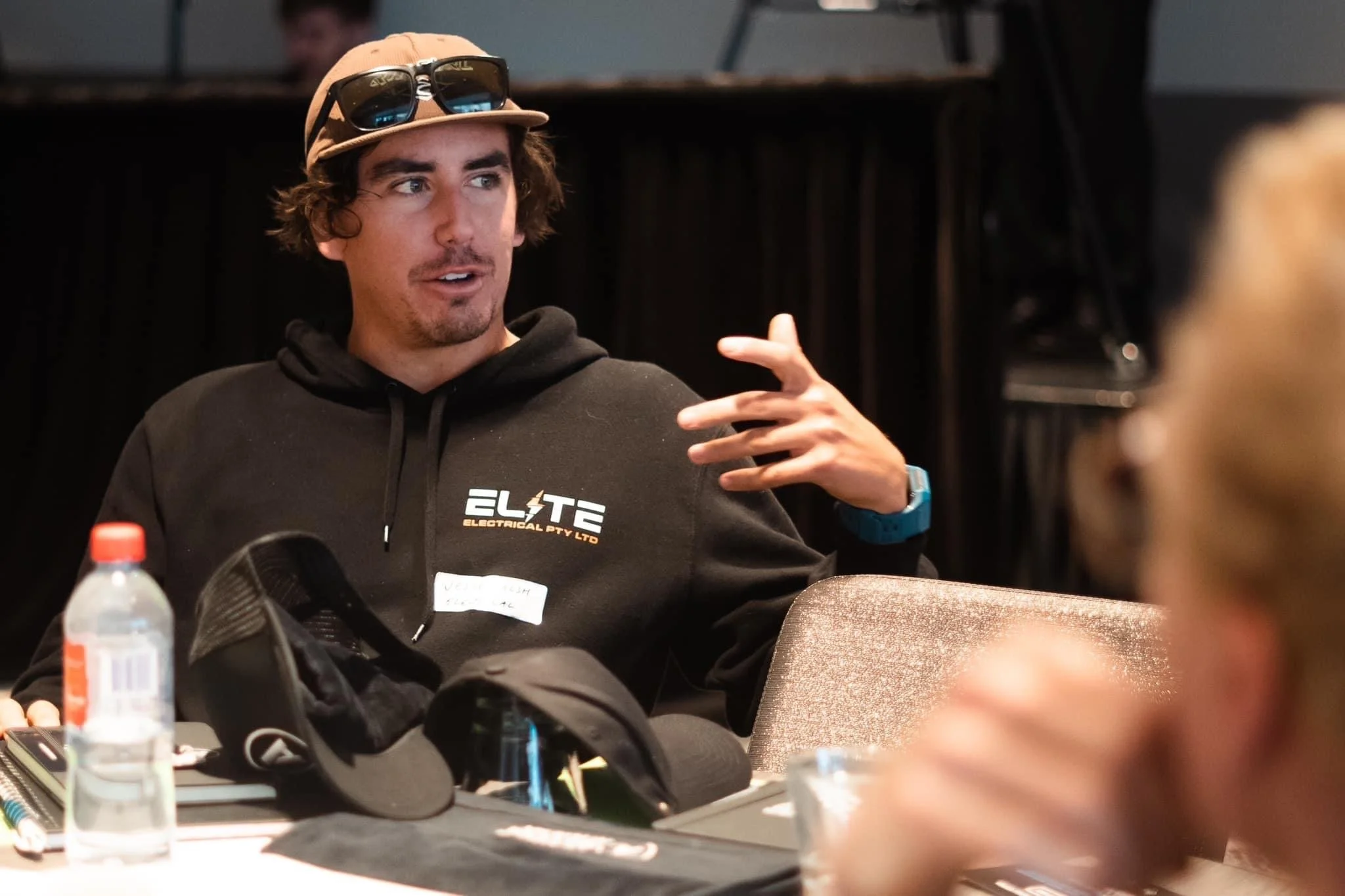 Elite Electrical team member wearing company hoodie speaking during a meeting