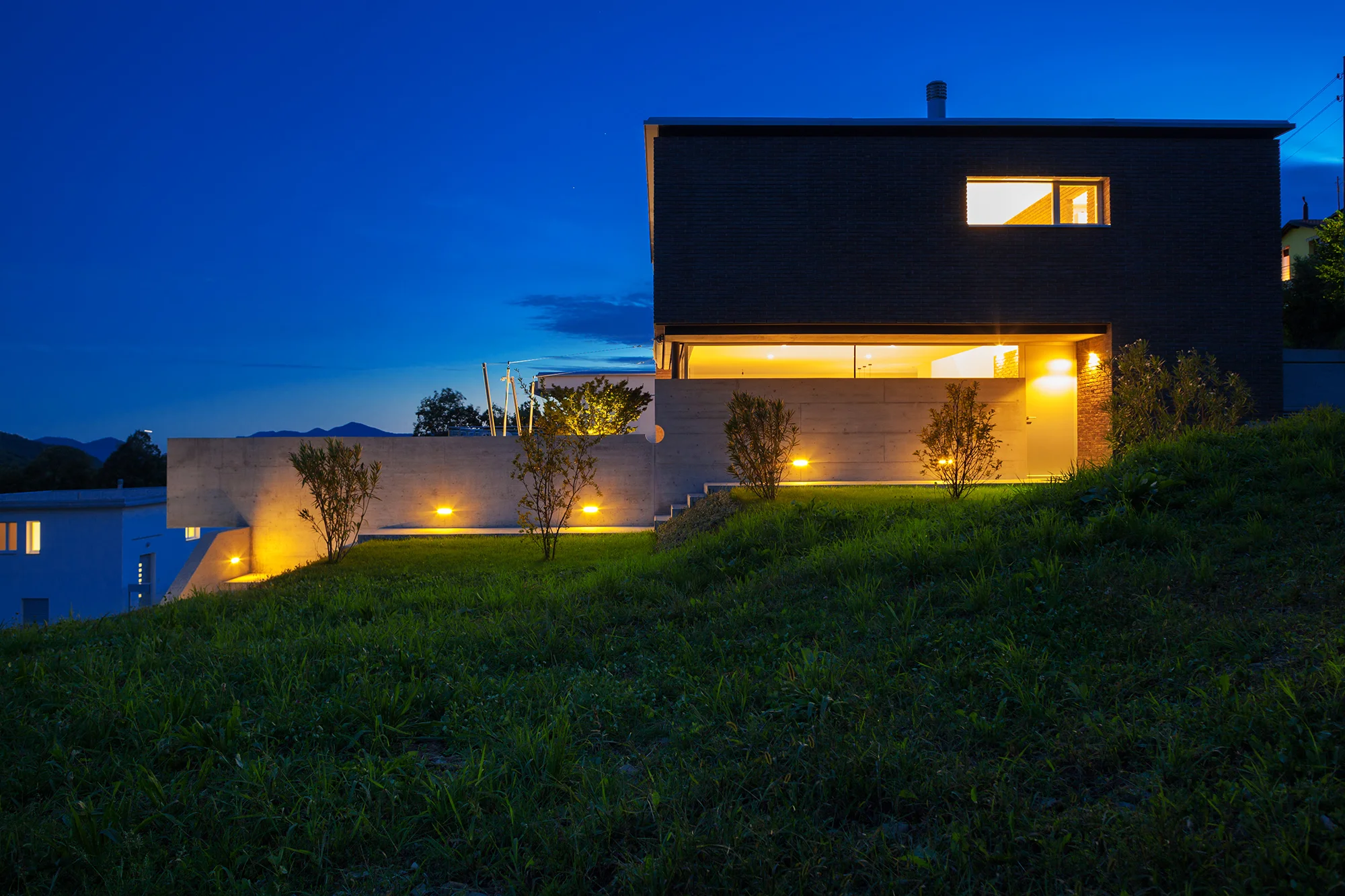 Modern home exterior with outdoor lighting at dusk