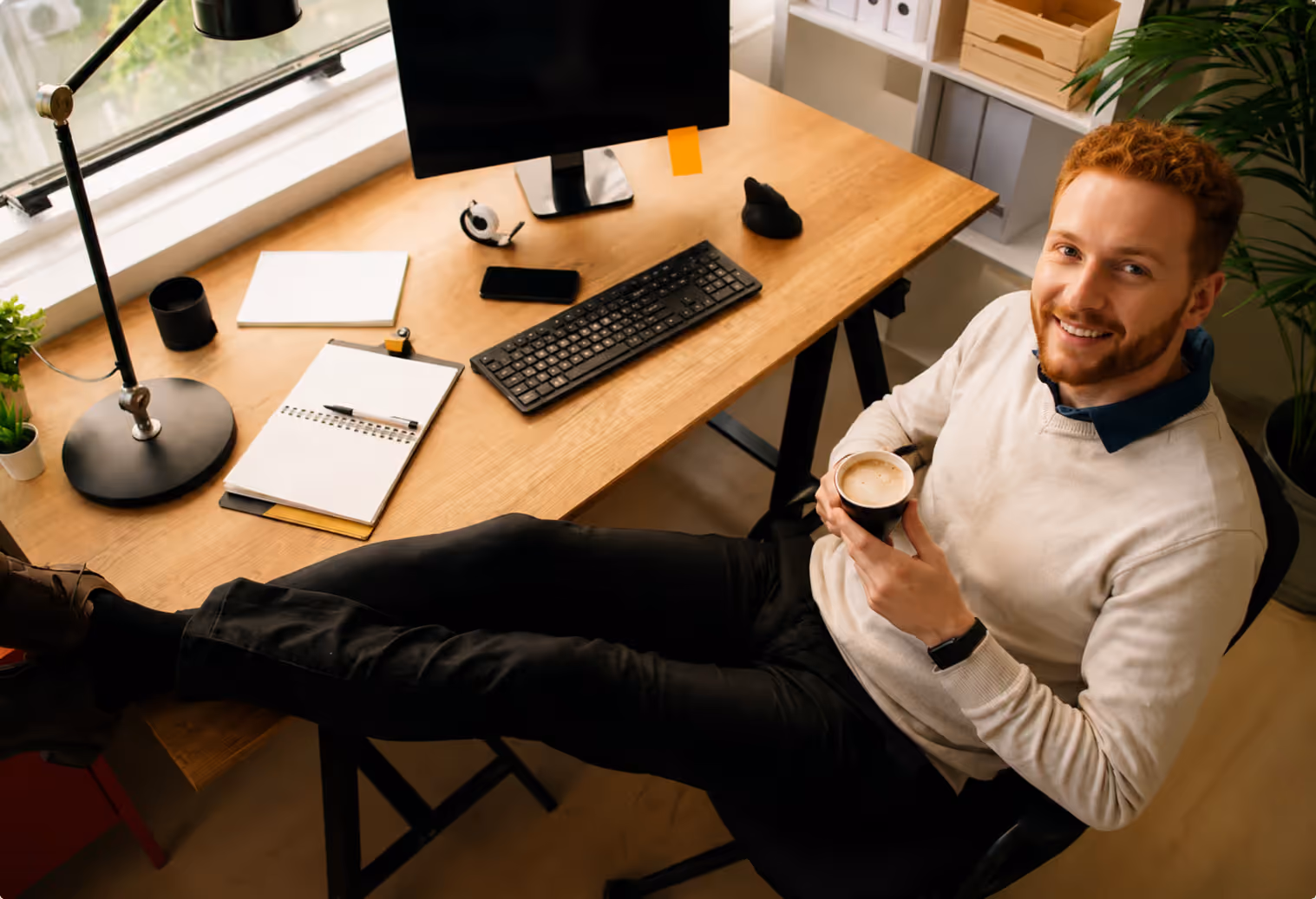 Ein junger Mann sitzt in seinem Büro und legt die Beine auf den Tisch. Weil er den Postversand mit der epostbox regelt sind Porto-Updates und Preiserhöhungen für Service & Wartung vergessen.