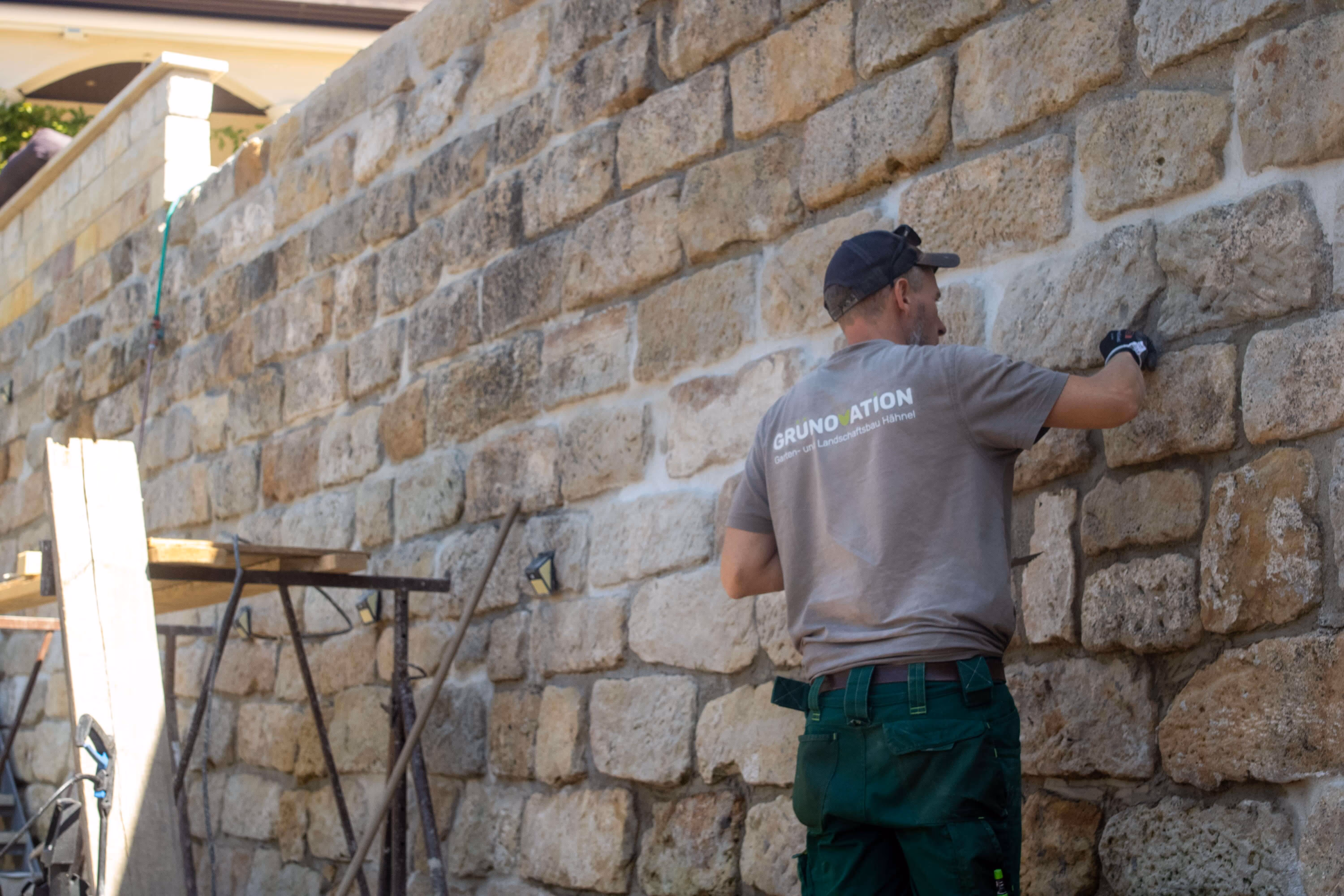 Ein Mitarbeiter beim Sanieren einer Mauer.