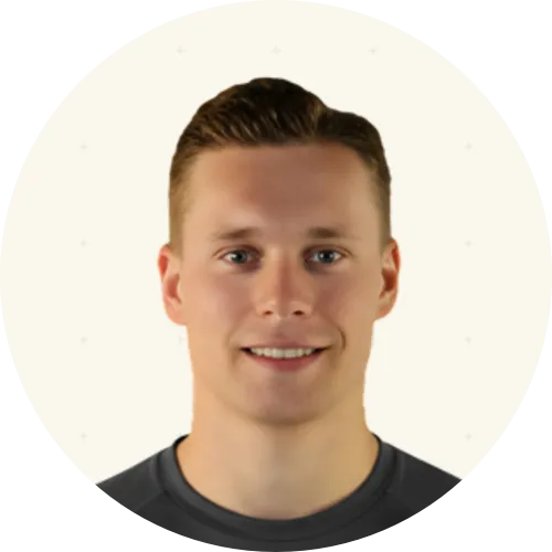 Portrait of a man with curly brown hair, wearing a dark shirt, and having heterochromia with one blue eye and one hazel eye.